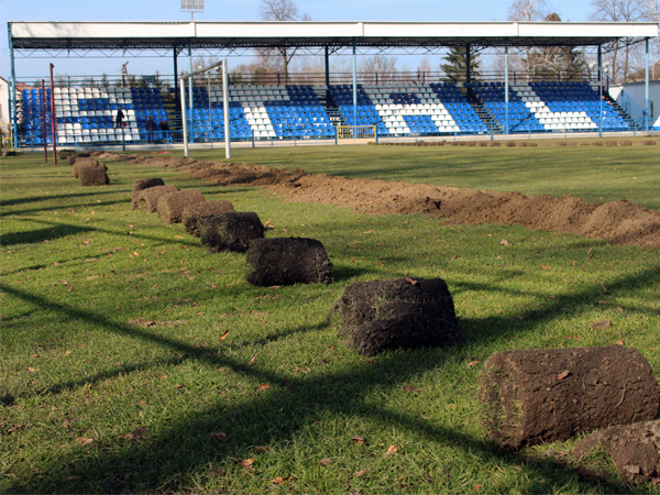 Na zdjęciu stadion sportowy Gminnego Ośrodka Sportu i Rekreacji w Gorzycach. Na murawie przygotowywana jest instalacja pod nawodnienie. Na zdjęciu widać wykop oraz zwoje ściągniętej trawy. W oddali widoczna jest trybuna z napisem „Stal”. 