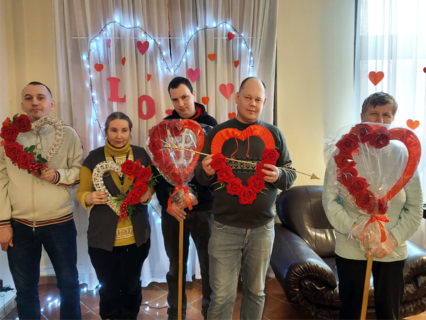 5 osób trzyma w rękach ozdoby w kształcie serc przygotowane przez podopiecznych Warsztatu Terapii Zajęciowej w Gorzycach