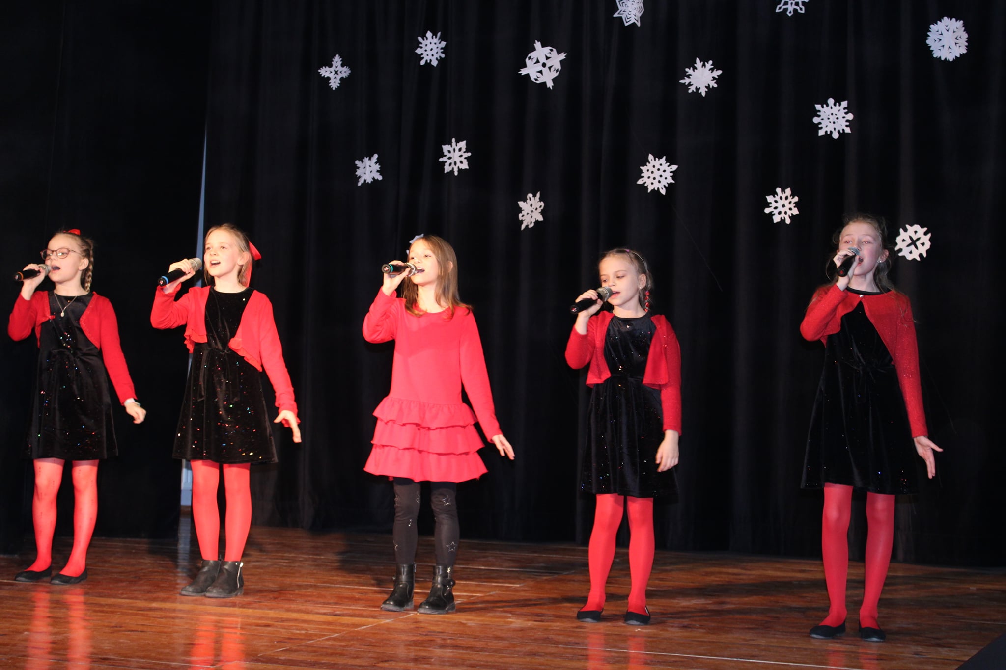 5 dziewczynek śpiewa na scenie.